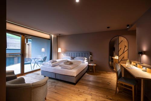 a bedroom with a bed and a balcony at Hotel Alpenroyal in Castelrotto