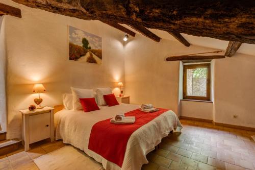 a bedroom with a large bed with red pillows at Les Juliannes - Gîte La Pierre Etoilée Piscine Jardin in Paulinet