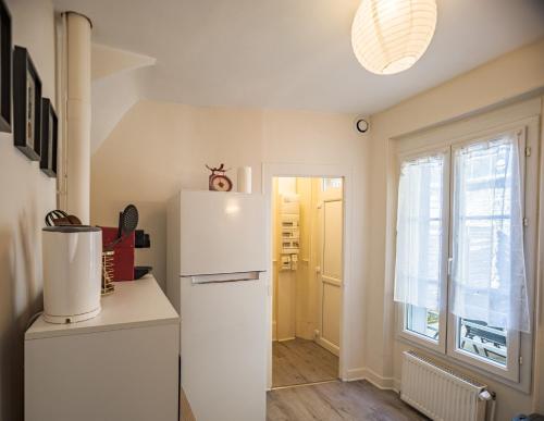 - un réfrigérateur blanc dans une cuisine avec fenêtre dans l'établissement Maison du Bonheur - Terrasse - Stationnement facile - Proche Hypercentre, à Troyes