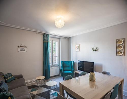 un salon avec une table et un canapé dans l'établissement Maison du Bonheur - Terrasse - Stationnement facile - Proche Hypercentre, à Troyes