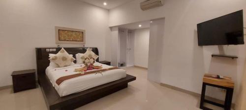 1 dormitorio con 1 cama y TV de pantalla plana en Kokomo Resort en Gili Trawangan