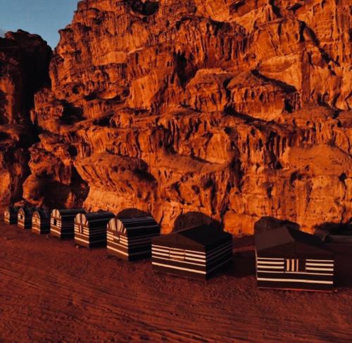 a row of black and white boxes in front of a mountain at Bedouin bunch camp in Wadi Rum