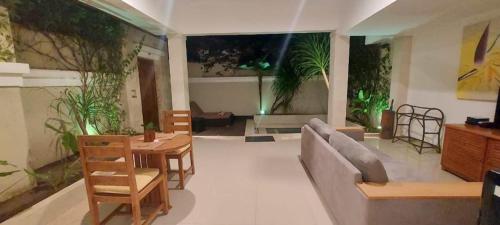 een woonkamer met een bank en tafels en planten bij Kokomo Resort in Gili Trawangan