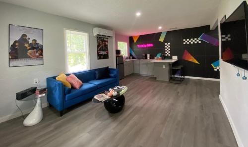 a living room with a blue couch and a kitchen at Totally 80s! in Sanford