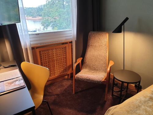 a room with a chair and a table and a window at Skåvsjöholm, hotell & konferens in Åkersberga