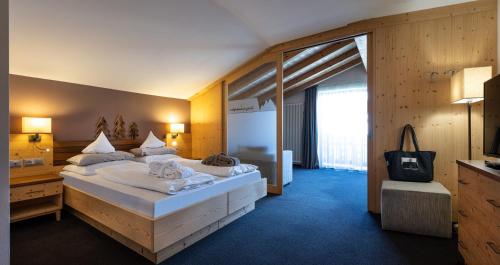 a bedroom with a large bed in a room at Hotel Alpenroyal in Castelrotto