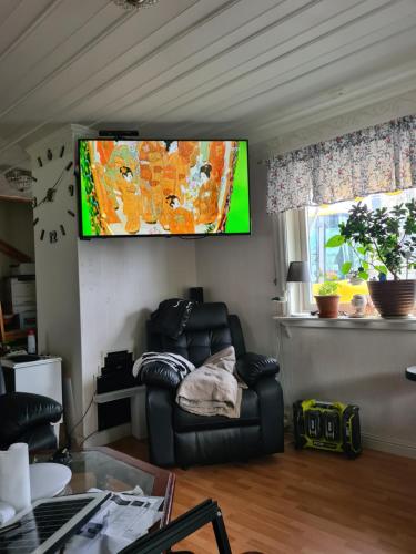 a living room with a couch and a tv on the wall at Nära Piteå havsbad in Piteå