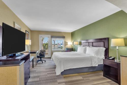 a hotel room with a bed and a flat screen tv at Holiday Inn Express Hotel & Suites El Centro by IHG in El Centro