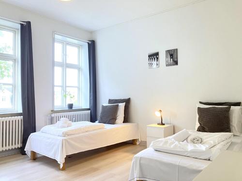 two beds in a white room with two windows at Three Bedroom Apartment In Kolding, Udsigten 4, in Kolding