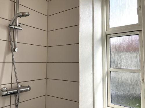 a shower in a bathroom with a window at Three Bedroom Apartment In Kolding, Udsigten 4, in Kolding