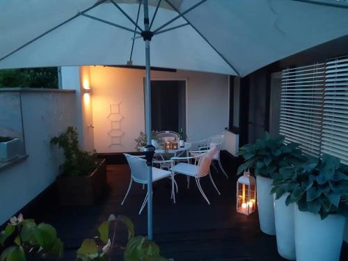 a patio with a table and chairs and an umbrella at Wohnung im Herzen der Altstadt in Schwaz