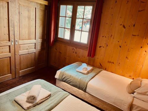 a bedroom with two beds with towels on them at Chalet Les Lanchettes in Morzine