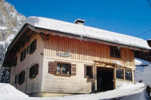 a log cabin with snow on the roof at Chalet Les Lanchettes in Morzine