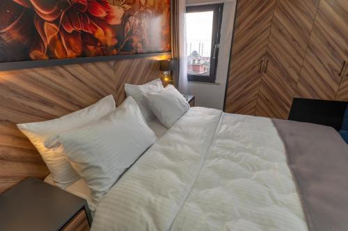 a bedroom with a bed with white sheets and pillows at Yusufhan Suites in Trabzon
