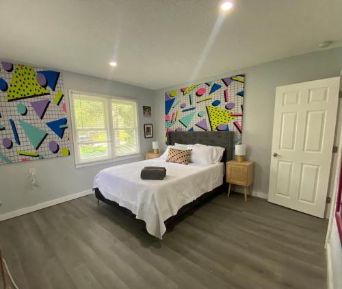 ein Schlafzimmer mit einem Bett und einem Wandgemälde in der Unterkunft Totally 80s! in Sanford