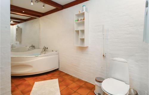 a bathroom with a tub and a toilet and a sink at Birknsgrd in Brædstrup