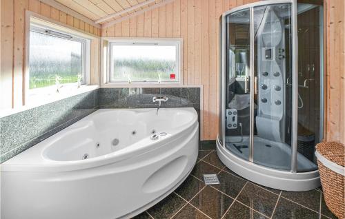 a bathroom with a large tub and a shower at Awesome Home In Sydals With Sauna in Skovbyballe