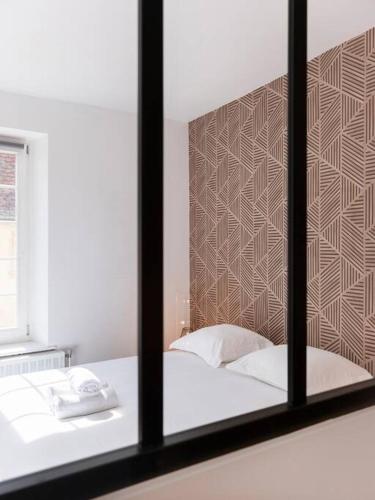 Cette chambre comprend un lit avec un miroir et un téléphone. dans l'établissement L'Alerion Nancéien - Appt pour 2 à Nancy, à Nancy