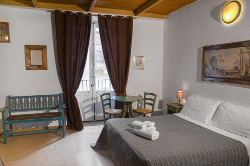 a bedroom with a bed and a chair and a window at I Vespri in Catania