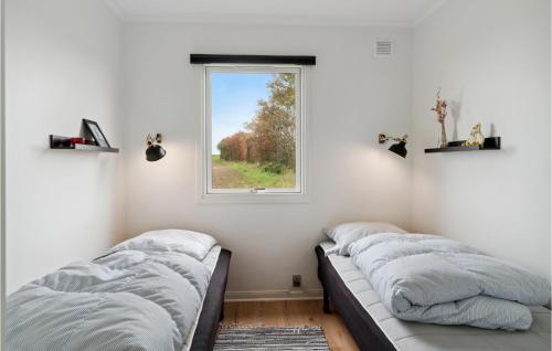 two beds in a room with a window at Gorgeous Home In Sams With Kitchen in Kolby Kås