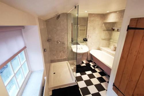 La salle de bains est pourvue d'un lavabo, d'une douche et d'un lavabo Ter H Hbestosbestos. dans l'établissement Charming 200 yr old Mill House right on the water, à Bristol