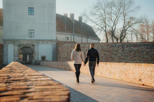 a man and a woman walking down a bridge at Berill Suites in Sárvár