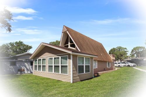 a house with a gambrel roof on a yard at Watch the Sunrise on Lake Louisa in Clermont