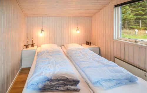 two beds in a small room with a window at Awesome Home In Lkken With Indoor Swimming Pool in Lønstrup