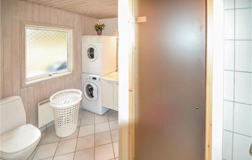 a bathroom with a washing machine and a washer and dryer at Awesome Home In Lkken With Indoor Swimming Pool in Lønstrup