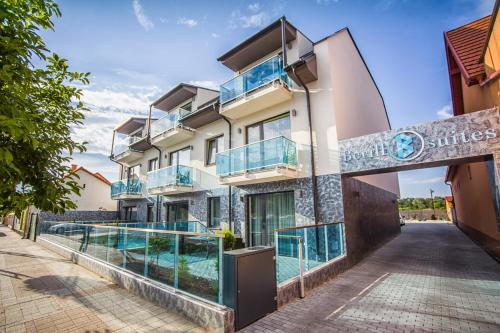 a building with a swimming pool in front of it at Berill Suites in Sárvár