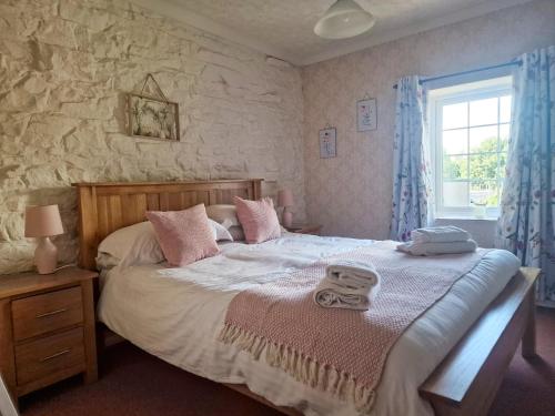 1 dormitorio con 1 cama con 2 toallas en Wetheral Cottages Package 1, en Great Salkeld