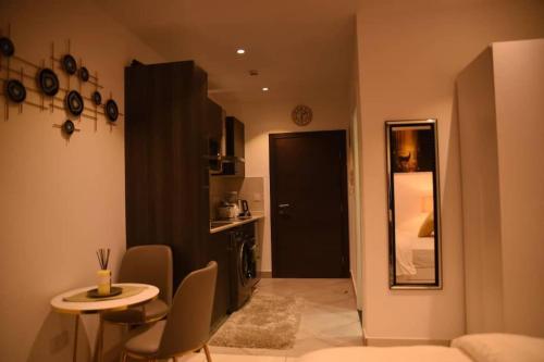 a living room with a table and chairs and a black door at The Luxe - @ Embassy Gardens Cantonments in Cantonments