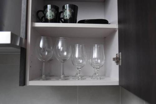 a row of wine glasses sitting on a shelf at The Luxe - @ Embassy Gardens Cantonments in Cantonments