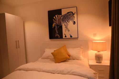 a bedroom with a bed with a picture of a zebra at The Luxe - @ Embassy Gardens Cantonments in Cantonments