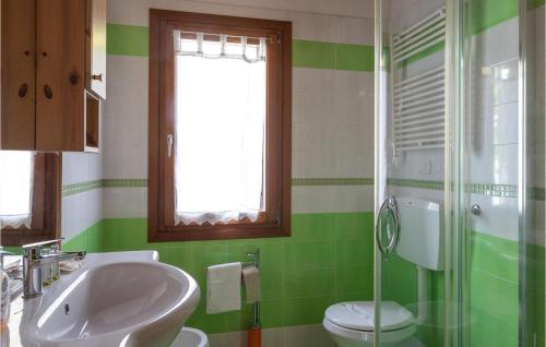 a green and white bathroom with a sink and a toilet at Stunning Apartment In Sacile -pd- With Swimming Pool in Sacile