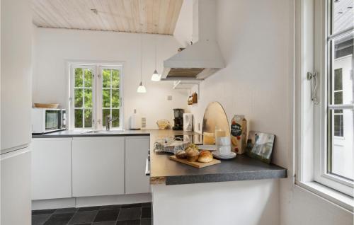 a kitchen with white cabinets and a counter top at Stunning Home In Rømø With Wifi in Havneby