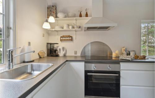a kitchen with white cabinets and a sink at Stunning Home In Rømø With Wifi in Havneby