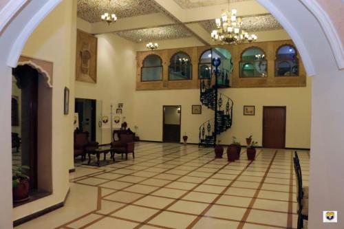 un vestíbulo vacío con una lámpara de araña y una escalera en Hotel Deoki Niwas Palace, en Jaisalmer