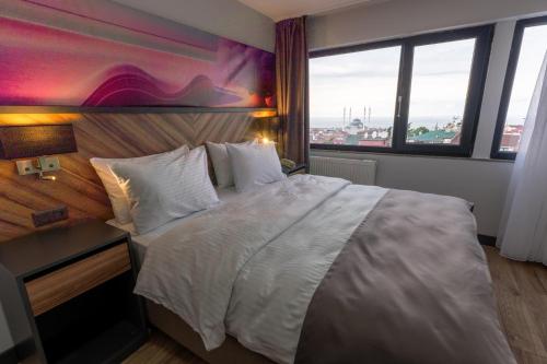a bedroom with a large bed and a large window at Yusufhan Suites in Trabzon