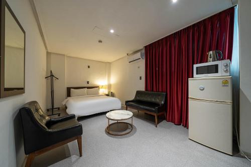 a hotel room with a bedroom with a bed at Pacific7 Hotel in Pyeongtaek