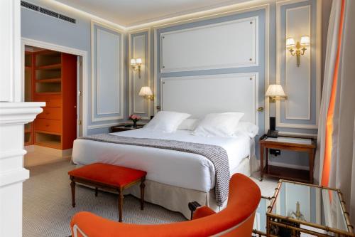 a hotel room with a bed and a red chair at Wellington Hotel & Spa Madrid in Madrid