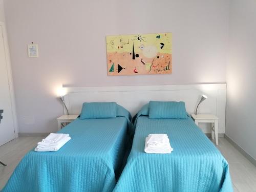 - 2 lits dans une chambre avec des draps bleus dans l'établissement Residenza Guglielmi, à Campobasso