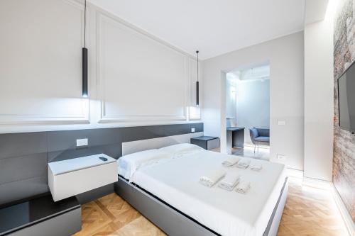 1 dormitorio con cama blanca y espejo en Beccaria - Florence luxury Apartment, en Florencia