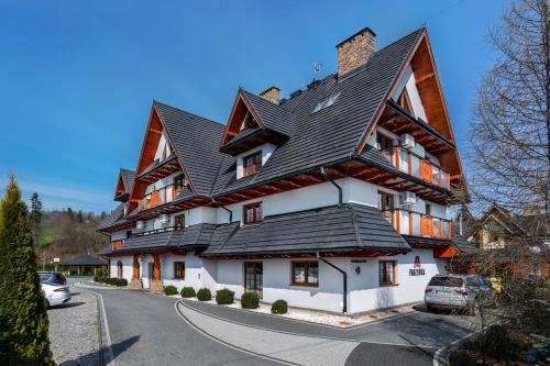 a large white house with a black roof at Parzenica B&B - Wyjątkowa i Jedyna!!! Sprawdź nas a nie pożałujesz! in Białka Tatrzanska