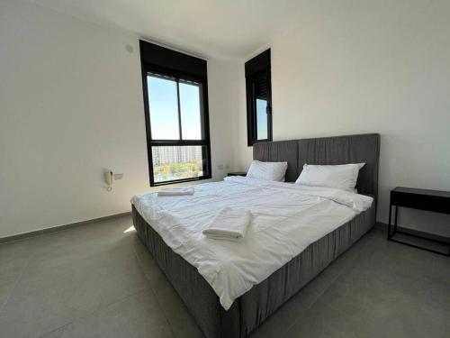 a bedroom with a large bed with white sheets at Menahem Arber 4 Bedroom in Tel Aviv