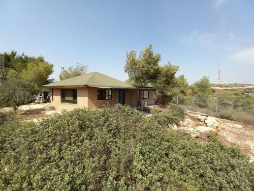 una casa sentada en la cima de una colina cubierta de hierba en בית בהר- בקתה יפיפיה בקצה הגלבוע en Sede Terumot