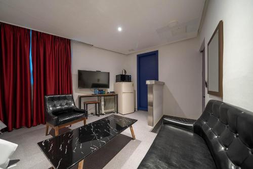 a living room with a couch and a television at Pacific7 Hotel in Pyeongtaek