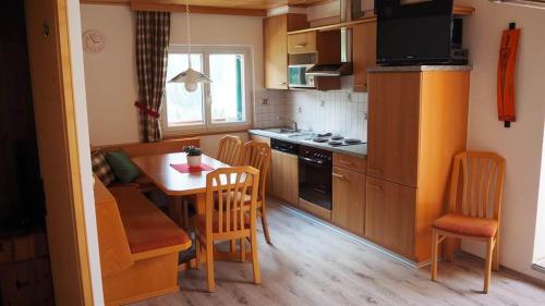 eine Küche mit einem Tisch und Stühlen sowie eine Küche mit einem Herd in der Unterkunft Haus Vallaster in Sankt Gallenkirch
