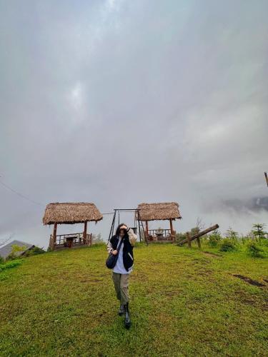 a person walking up a hill with a swing at Homestay Chân Mây Chiêu Lầu Thi in Hoàng Su Phì