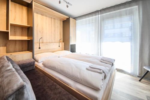 ein Schlafzimmer mit einem großen Bett und einem großen Fenster in der Unterkunft Appartement Bittner in Saalbach-Hinterglemm